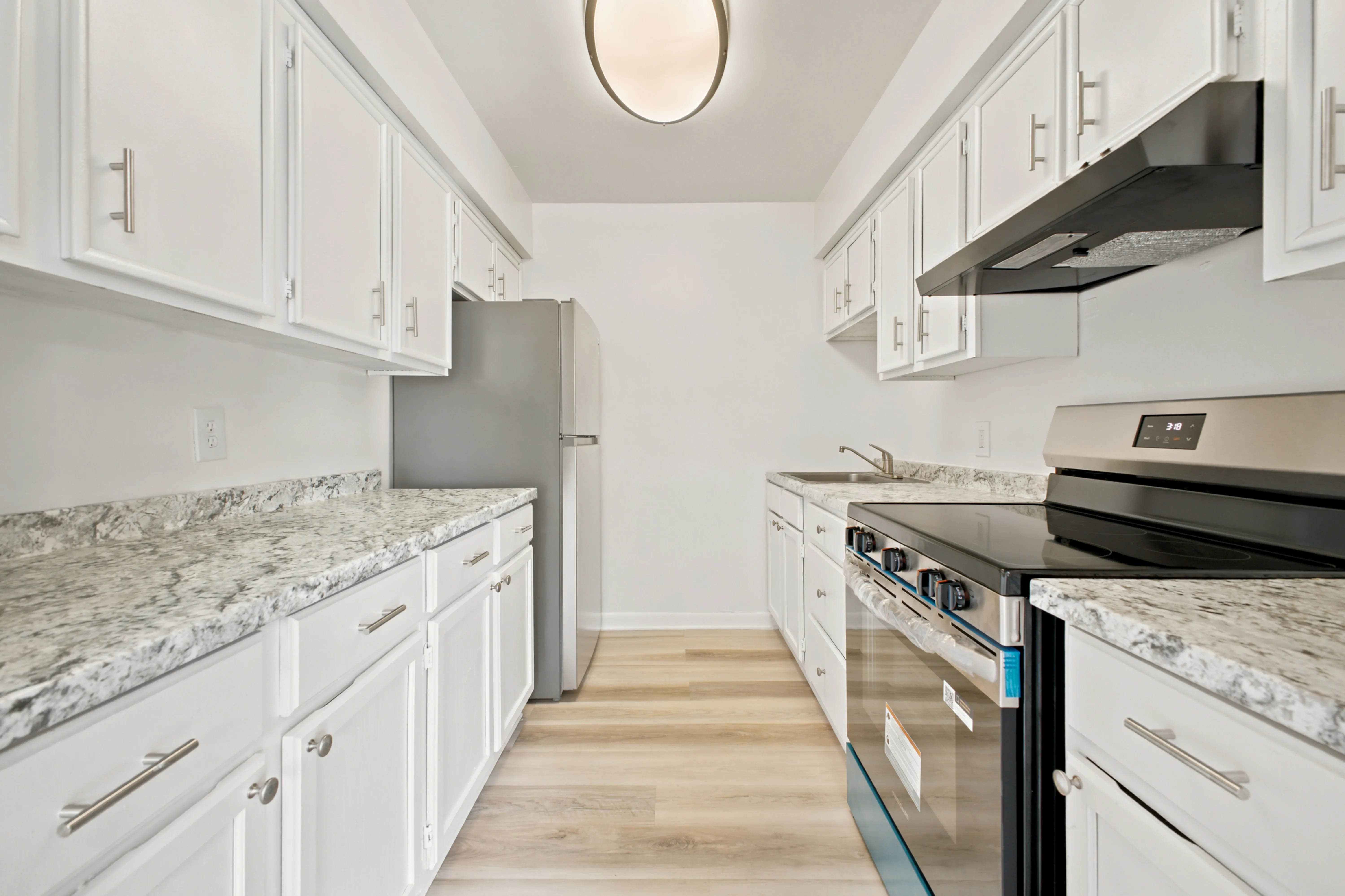 Kitchen with white cabinets, granite-look counters and stainless range
