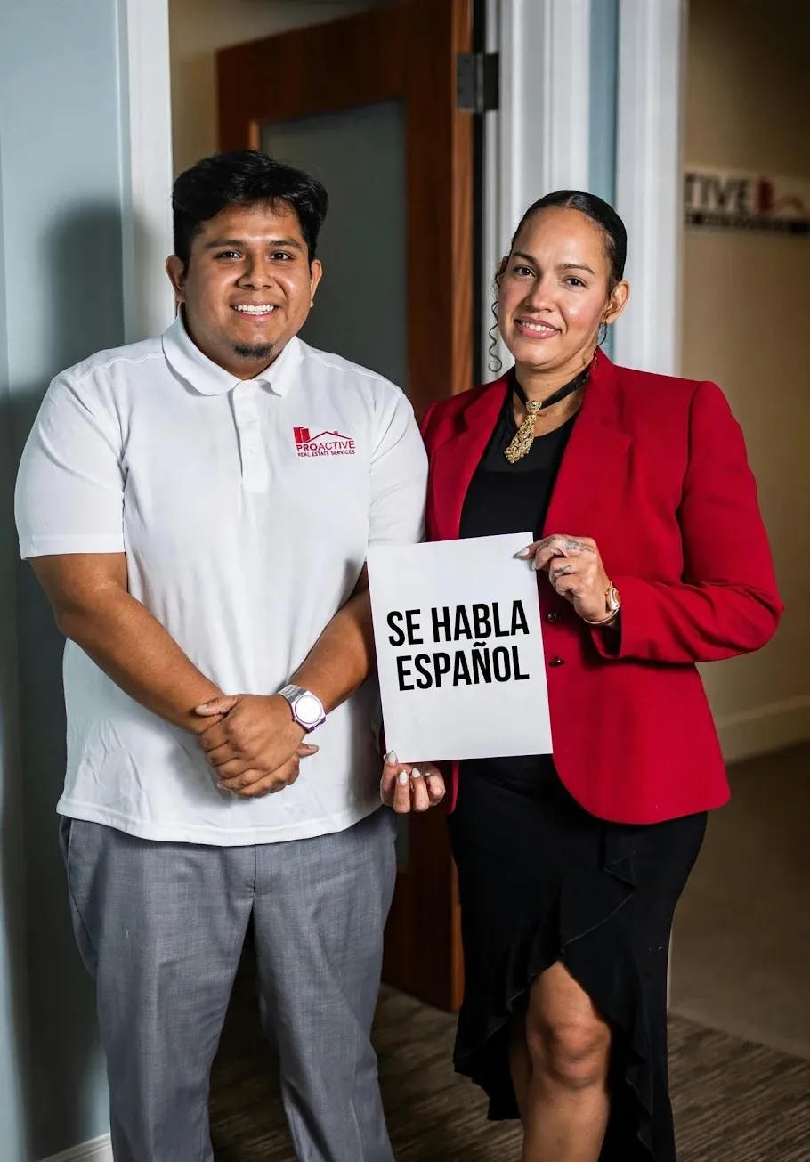 Two members of the River Oaks leasing team, one holding a sign that reads “Se habla español”