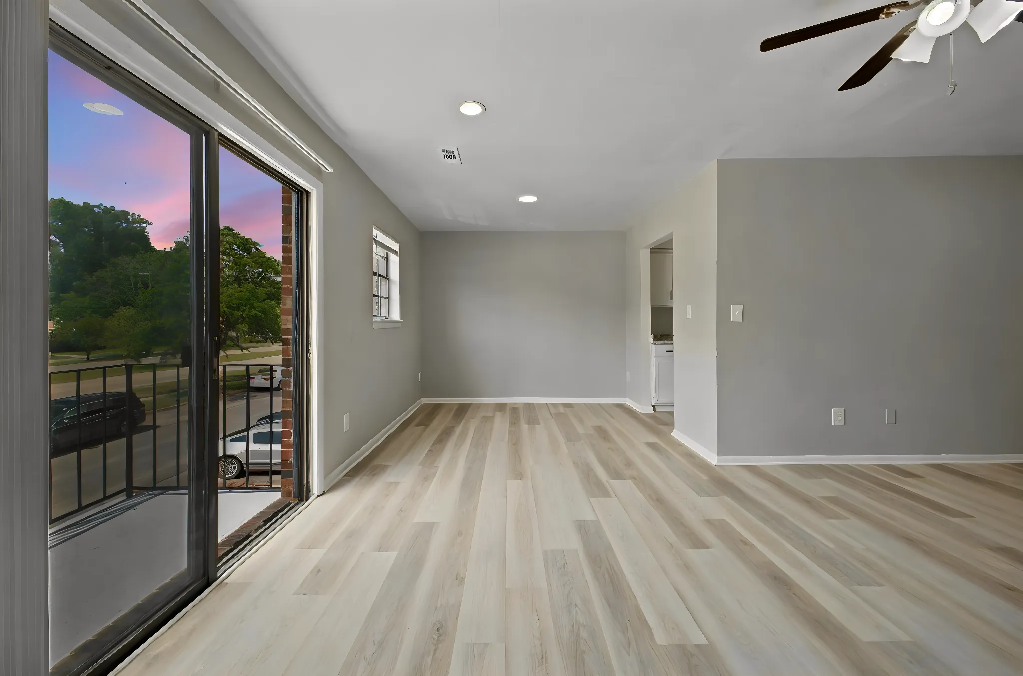 Renovated living room with sliding doors to a private balcony at dusk